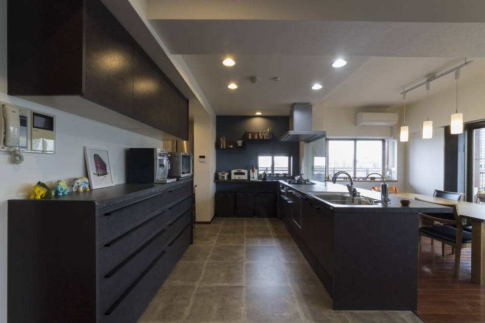 Diseño de cocina lineal moderna grande abierta con fregadero de un seno, puertas de armario negras, suelo de linóleo, península, suelo gris y encimeras negras