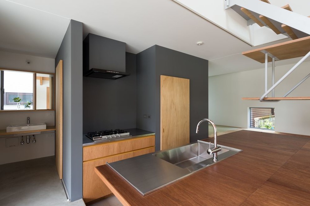 Mid-sized minimalist galley cork floor, gray floor and shiplap ceiling open concept kitchen photo in Tokyo with an integrated sink, flat-panel cabinets, medium tone wood cabinets, stainless steel countertops, gray backsplash, stainless steel appliances, an island and brown countertops