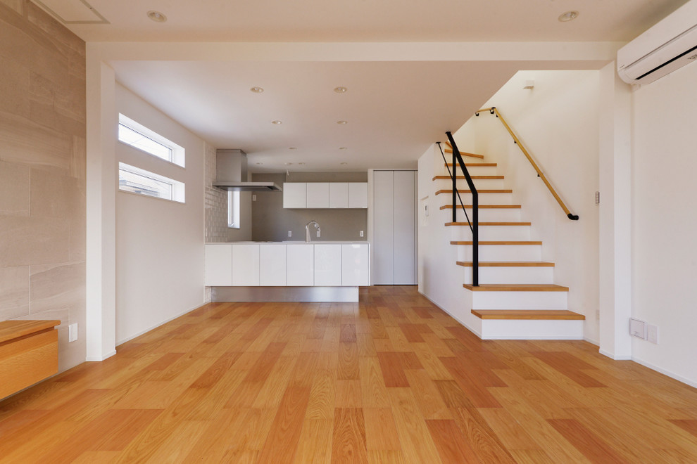 Immagine di una cucina minimalista con paraspruzzi bianco, pavimento in compensato e top bianco