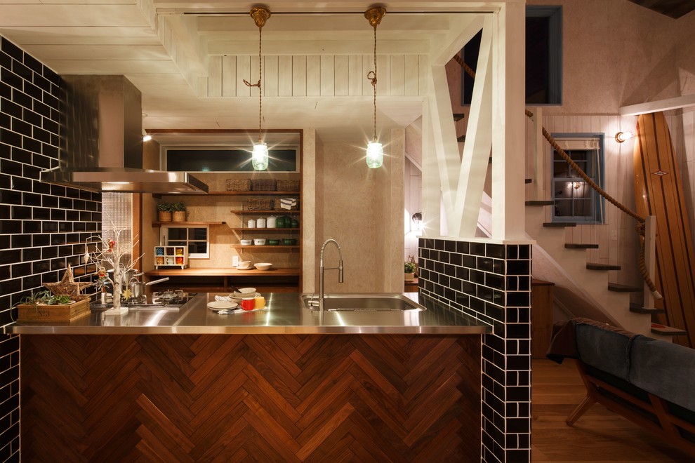 Exempel på ett maritimt linjärt kök med öppen planlösning, med en enkel diskho, bänkskiva i rostfritt stål, mellanmörkt trägolv, en halv köksö och brunt golv