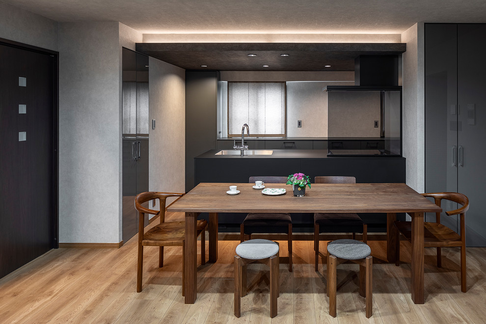 東京23区にあるモダンスタイルのおしゃれなキッチン (アンダーカウンターシンク、インセット扉のキャビネット、グレーのキャビネット、メタリックのキッチンパネル、黒い調理設備、淡色無垢フローリング、ベージュの床、黒いキッチンカウンター) の写真