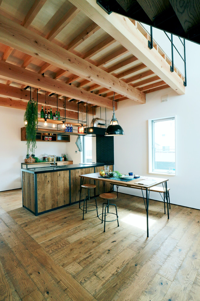他の地域にあるインダストリアルスタイルのおしゃれなキッチン (無垢フローリング、茶色い床) の写真