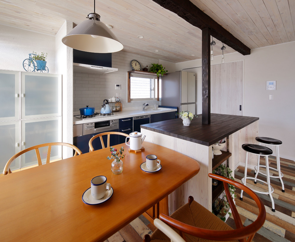 Inspiration för ett skandinaviskt linjärt kök med öppen planlösning, med en integrerad diskho, vitt stänkskydd, målat trägolv, en köksö och flerfärgat golv