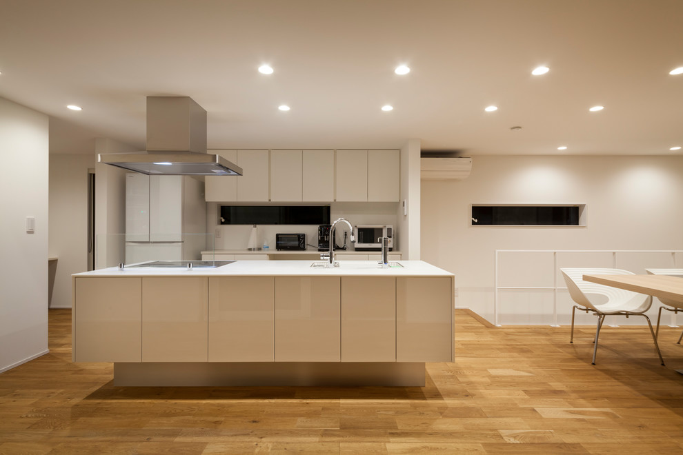 Immagine di una cucina moderna con pavimento marrone e top bianco