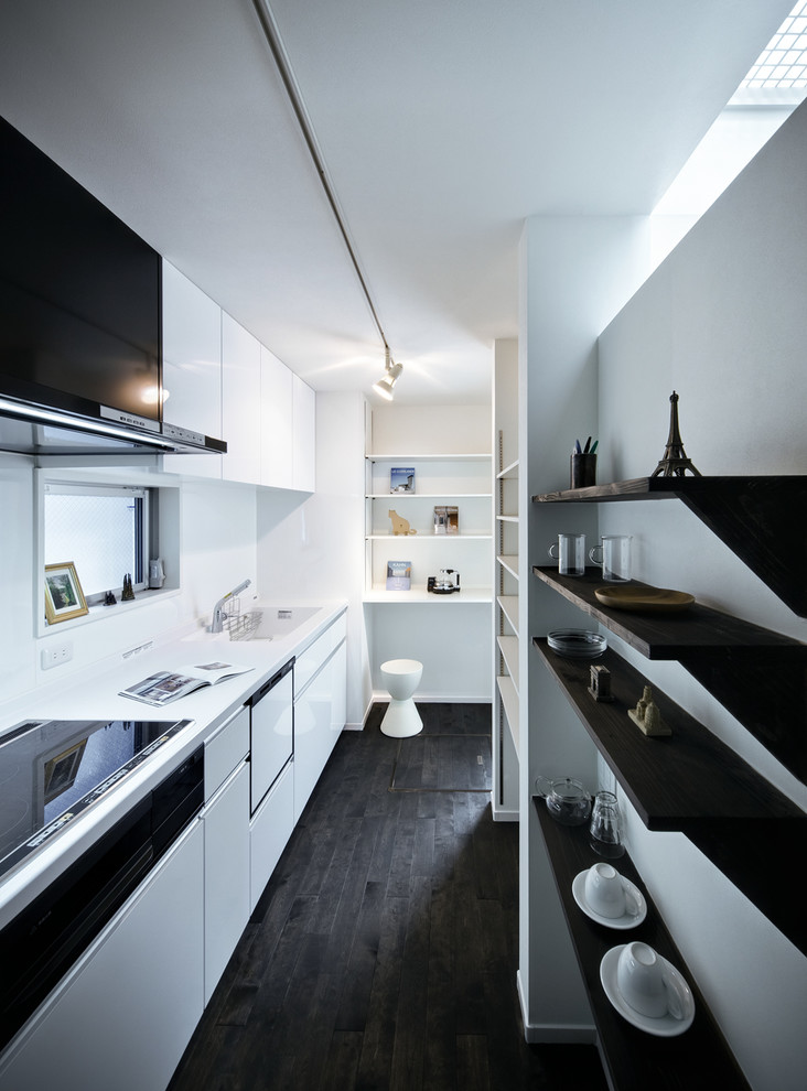 На фото: отдельная, параллельная кухня в стиле модернизм с белыми фасадами, белым фартуком, монолитной мойкой, деревянным полом и шторами на окнах