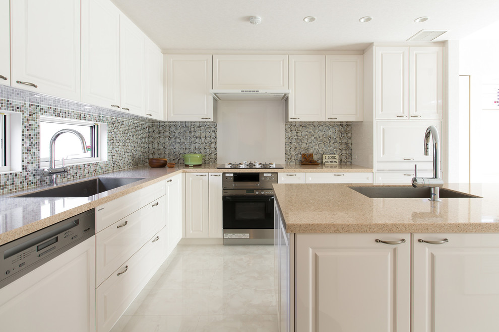 トラディショナルスタイルのおしゃれなキッチン (アンダーカウンターシンク、インセット扉のキャビネット、白いキャビネット、クオーツストーンカウンター、マルチカラーのキッチンパネル、モザイクタイルのキッチンパネル、パネルと同色の調理設備、白い床) の写真