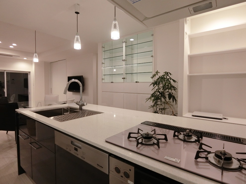 Exempel på ett mellanstort modernt kök, med en undermonterad diskho, släta luckor, svarta skåp, bänkskiva i kvarts, grått stänkskydd, stänkskydd i sten, rostfria vitvaror, plywoodgolv, en halv köksö och vitt golv