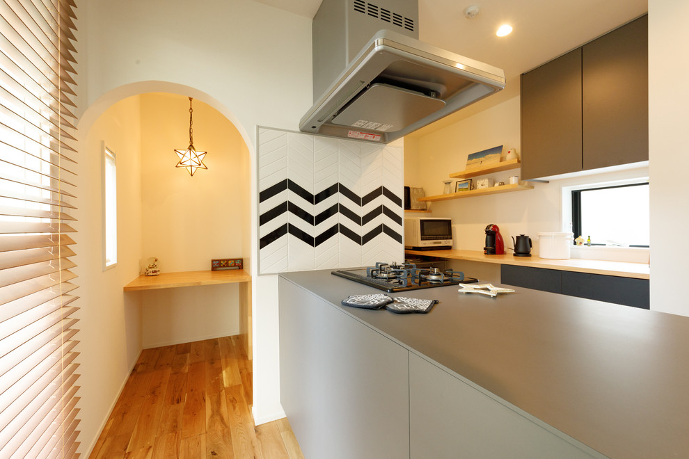Idéer för att renovera ett mellanstort minimalistiskt linjärt skafferi, med mellanmörkt trägolv, en halv köksö och brunt golv