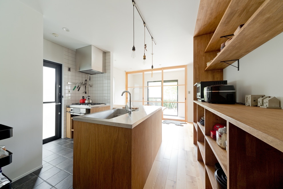 Immagine di una cucina contemporanea di medie dimensioni con lavello sottopiano, top in acciaio inossidabile, paraspruzzi con piastrelle diamantate, pavimento grigio e top marrone