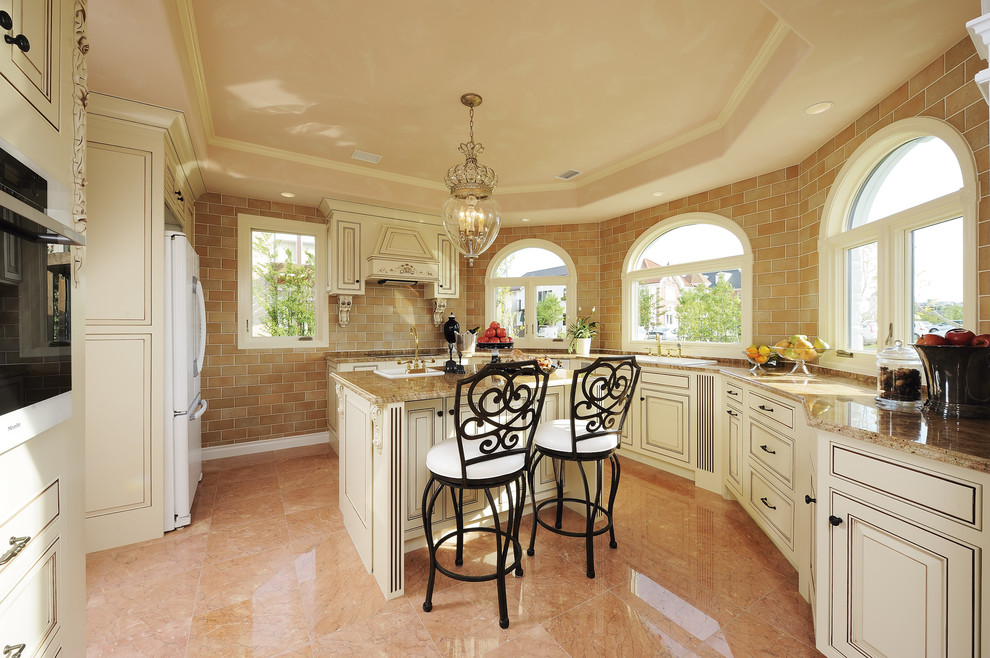 Foto di una cucina vittoriana chiusa con lavello da incasso, ante con riquadro incassato, ante bianche, top in granito, paraspruzzi marrone e pavimento arancione