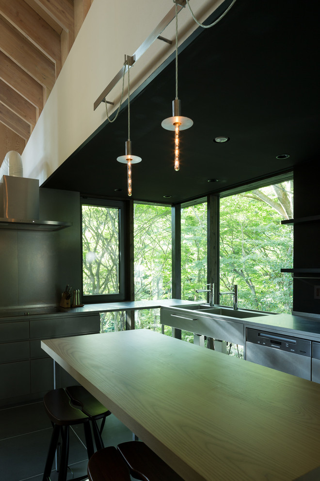 Large modern l-shaped enclosed kitchen in Tokyo Suburbs with a double-bowl sink, stainless steel worktops, black splashback, stainless steel appliances and marble flooring.