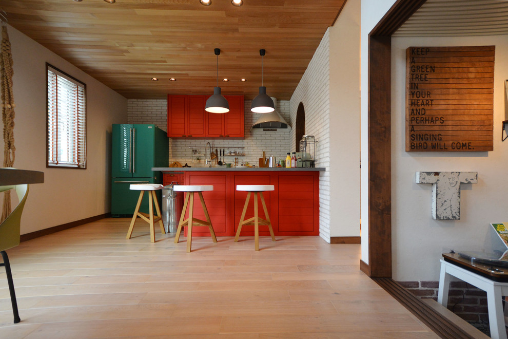 Пример оригинального дизайна: прямая кухня-гостиная в стиле кантри с оранжевыми фасадами, оранжевым фартуком, светлым паркетным полом, островом, белым полом и зеленой столешницей