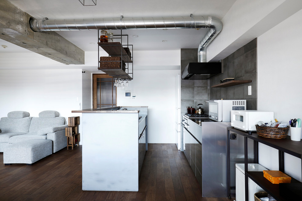 東京23区にあるアジアンスタイルのおしゃれなキッチン (アンダーカウンターシンク、フラットパネル扉のキャビネット、グレーのキャビネット、グレーのキッチンパネル、白い調理設備、濃色無垢フローリング、茶色い床) の写真