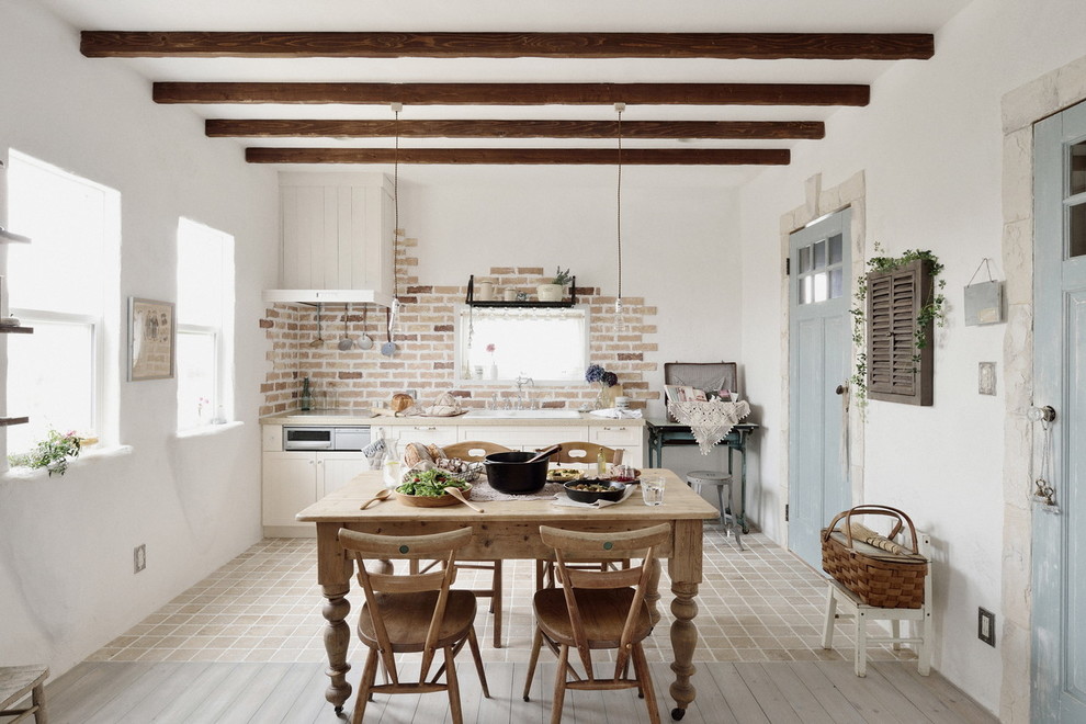 他の地域にある地中海スタイルのおしゃれなI型キッチン (白いキャビネット、磁器タイルの床) の写真