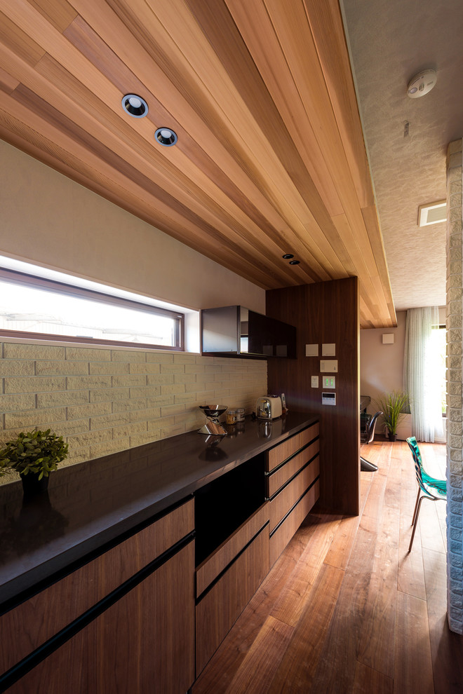 Example of a minimalist single-wall dark wood floor and brown floor open concept kitchen design in Other with a single-bowl sink, flat-panel cabinets, turquoise cabinets, solid surface countertops, white backsplash and a peninsula