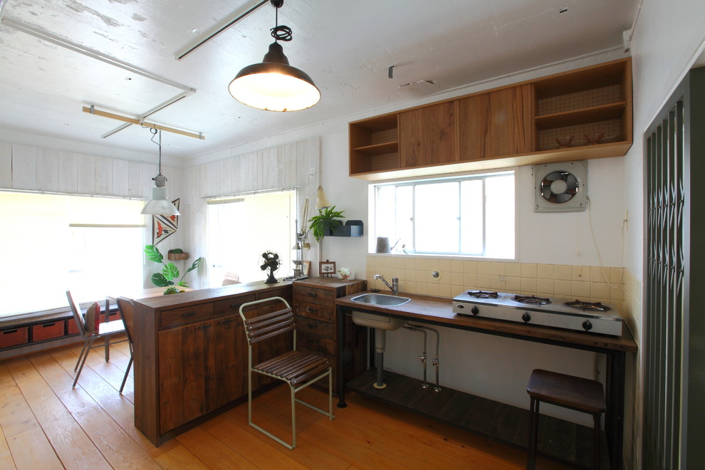 名古屋にある小さなインダストリアルスタイルのおしゃれなキッチン (シングルシンク、木材カウンター、ベージュキッチンパネル、無垢フローリング、茶色い床、茶色いキッチンカウンター) の写真