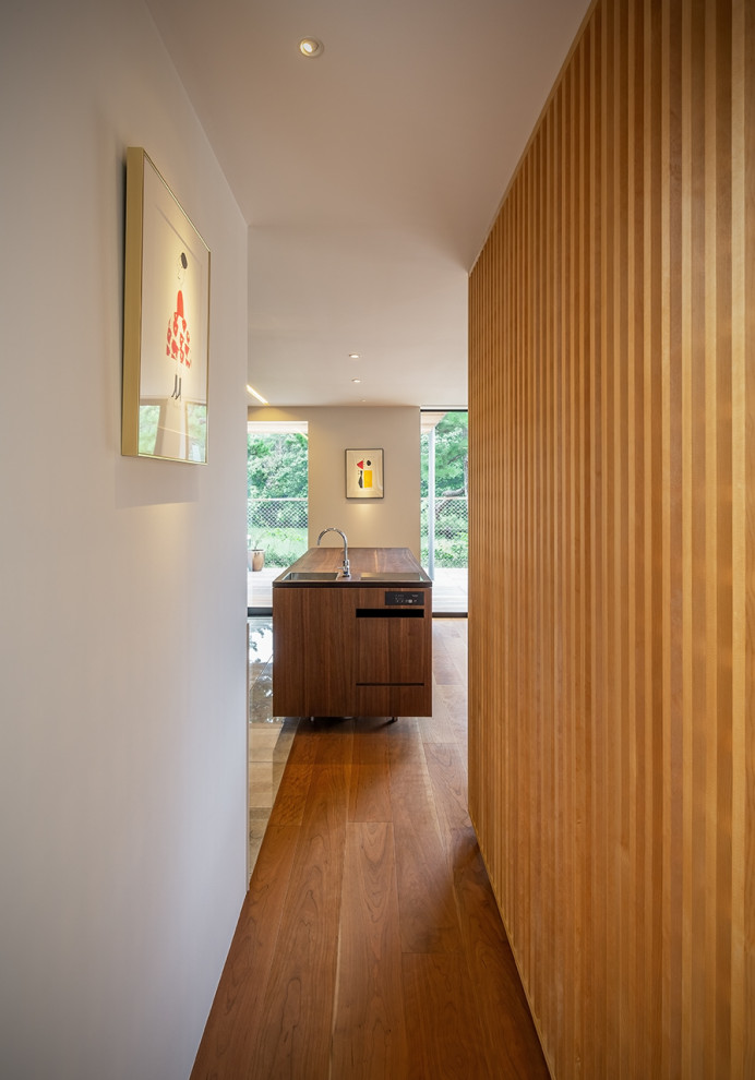 Idée de décoration pour une cuisine ouverte parallèle en bois brun avec un plafond en lambris de bois, un évier encastré, un placard à porte affleurante, un plan de travail en bois, un sol en carrelage de porcelaine et un sol beige.