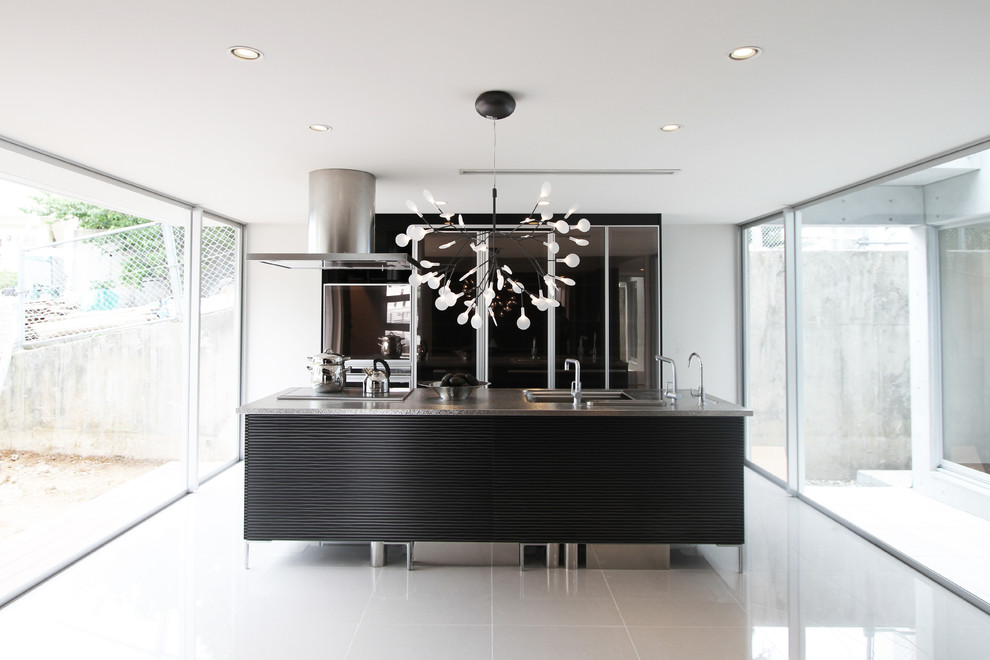 Zweizeilige Moderne Küche mit integriertem Waschbecken, flächenbündigen Schrankfronten, braunen Schränken, Edelstahl-Arbeitsplatte, Kücheninsel und grauem Boden in Sonstige