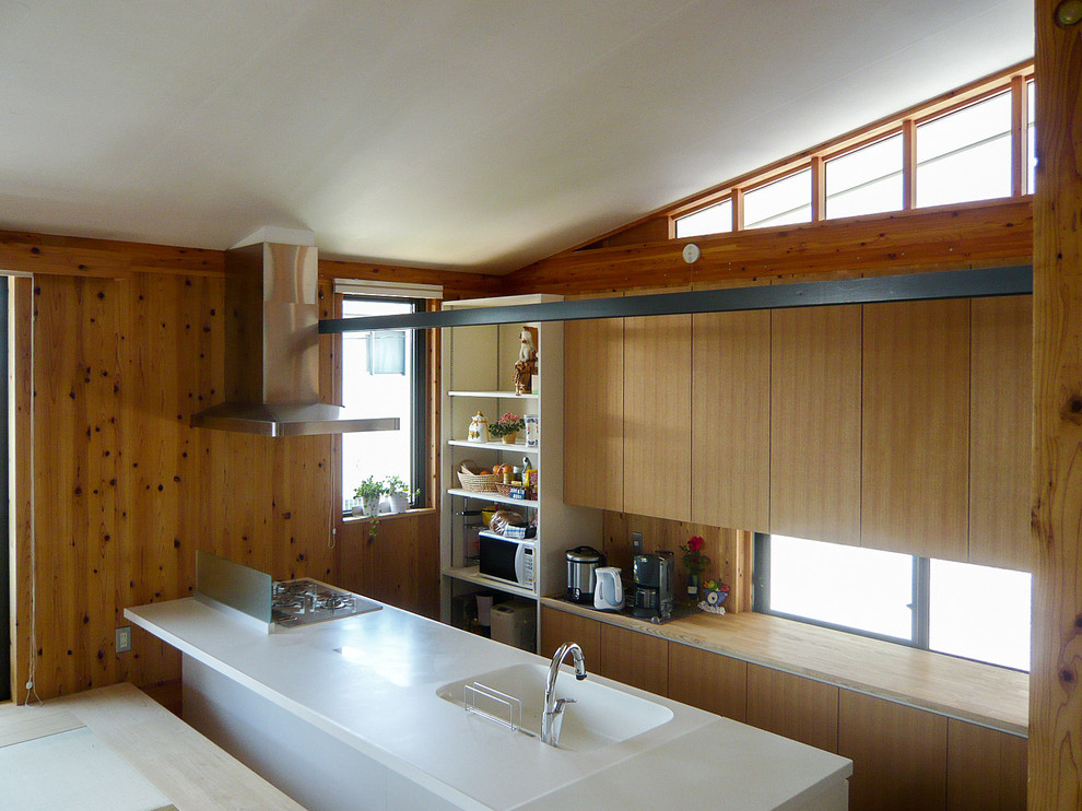 Foto på ett mellanstort lantligt vit linjärt kök med öppen planlösning, med en integrerad diskho, släta luckor, skåp i mellenmörkt trä, bänkskiva i koppar, rostfria vitvaror, en köksö, brunt golv och korkgolv