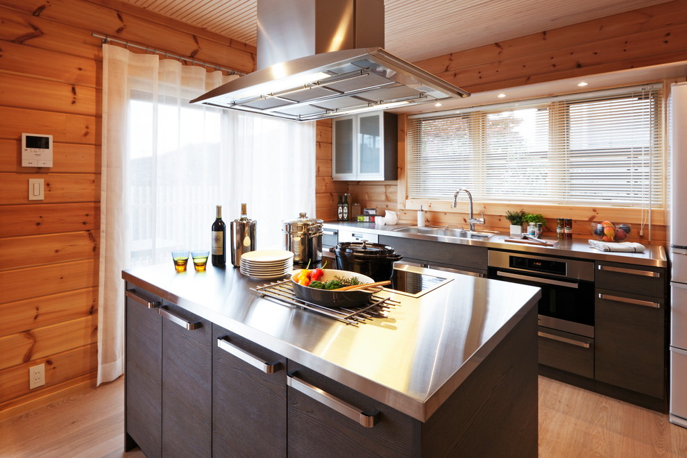 Пример оригинального дизайна: кухня в восточном стиле с монолитной мойкой, столешницей из нержавеющей стали и островом