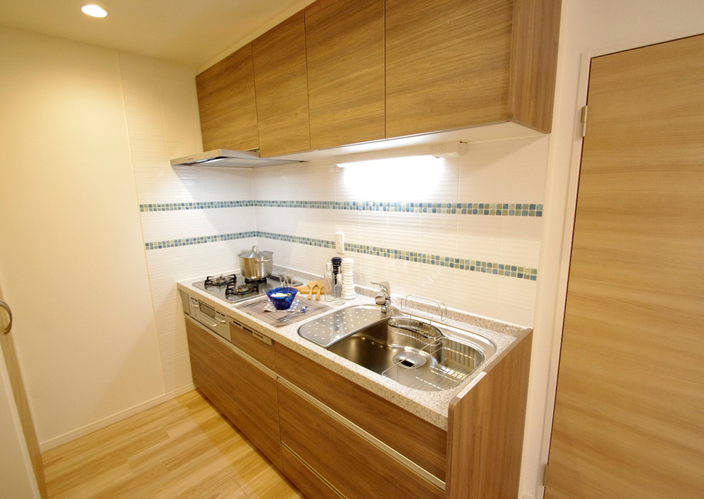 Foto på ett funkis linjärt kök och matrum, med en undermonterad diskho, släta luckor, skåp i mellenmörkt trä, bänkskiva i koppar, vitt stänkskydd, stänkskydd i keramik och mellanmörkt trägolv