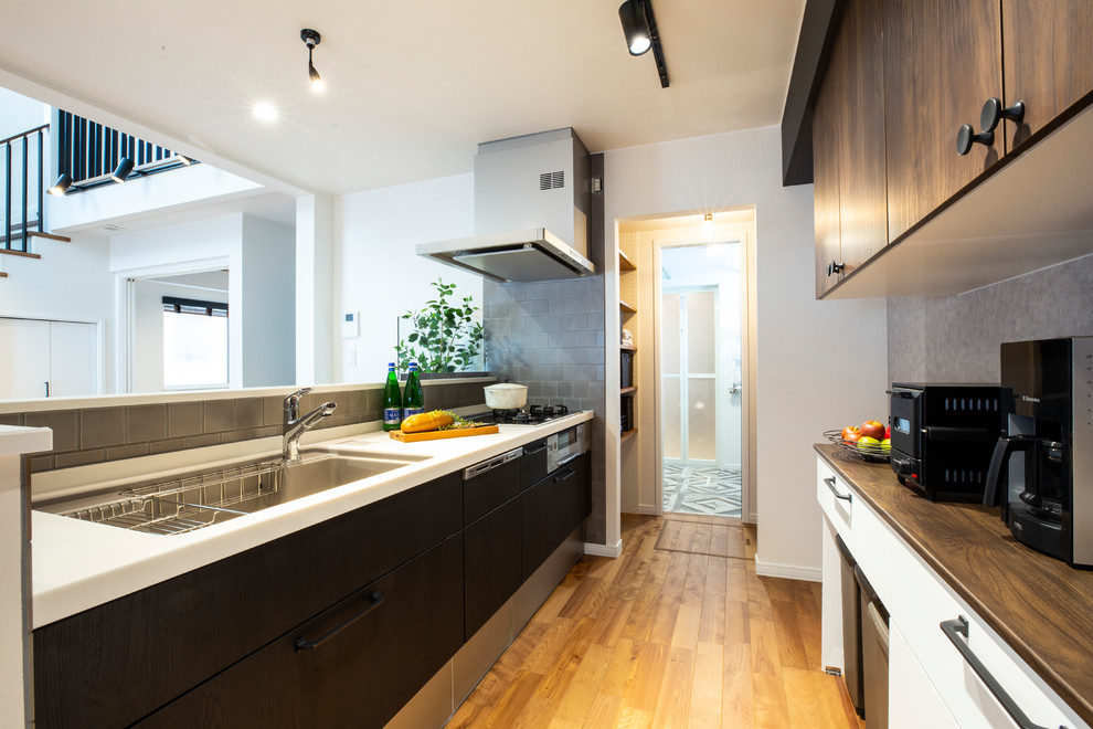 Идея дизайна: прямая кухня-гостиная в стиле лофт с одинарной мойкой, плоскими фасадами, паркетным полом среднего тона, полуостровом и коричневым полом