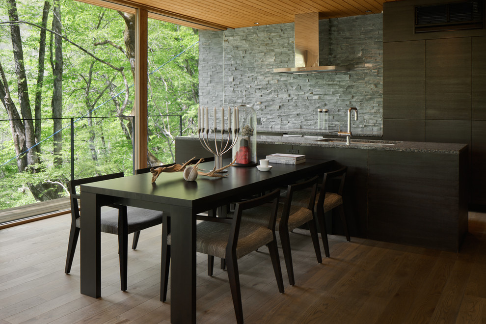 Idee per una cucina stile rurale con lavello a doppia vasca, ante lisce, ante nere, paraspruzzi grigio, pavimento in legno massello medio, pavimento marrone e top grigio