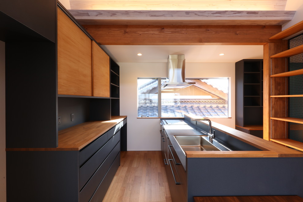 This is an example of a small modern single-wall open plan kitchen in Other with a submerged sink, open cabinets, black cabinets, composite countertops, brown splashback, wood splashback, integrated appliances, plywood flooring, an island, brown floors and black worktops.