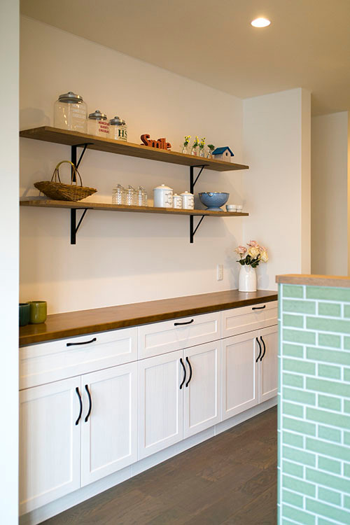 Inredning av ett minimalistiskt grön linjärt grönt kök med öppen planlösning, med en enkel diskho, skåp i ljust trä, bänkskiva i koppar, en halv köksö, brunt golv, släta luckor och mellanmörkt trägolv