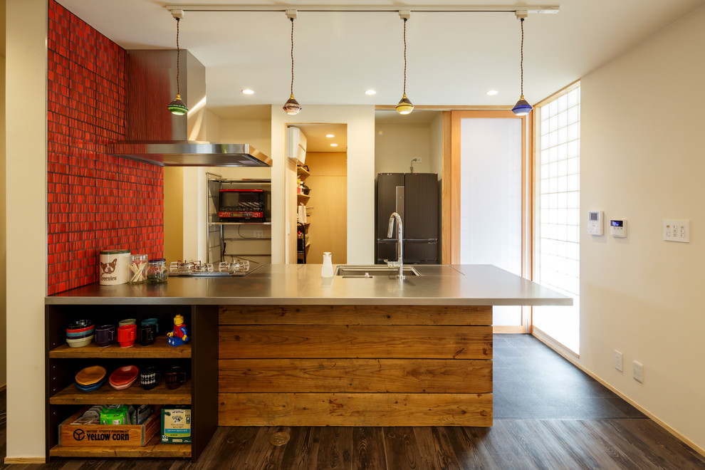 エクレクティックスタイルのおしゃれなキッチン (シングルシンク、ステンレスカウンター、濃色無垢フローリング、茶色い床) の写真