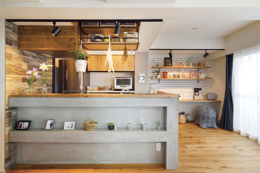 Open concept kitchen - zen single-wall medium tone wood floor and brown floor open concept kitchen idea in Tokyo with flat-panel cabinets, medium tone wood cabinets and a peninsula