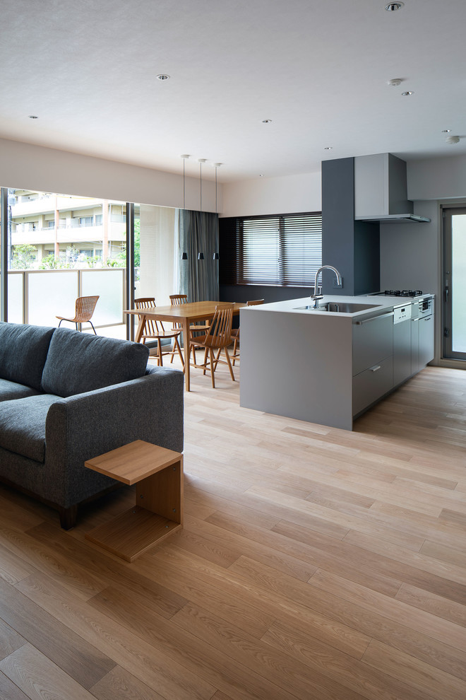 Photo of a small contemporary galley open plan kitchen in Osaka with a built-in sink, grey cabinets, plywood flooring, an island and beige floors.