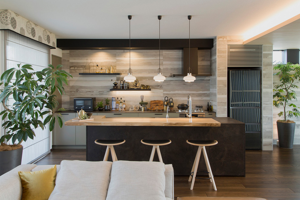 Single-wall brown floor open concept kitchen photo in Tokyo with an undermount sink, beaded inset cabinets, distressed cabinets, black appliances, an island and black countertops