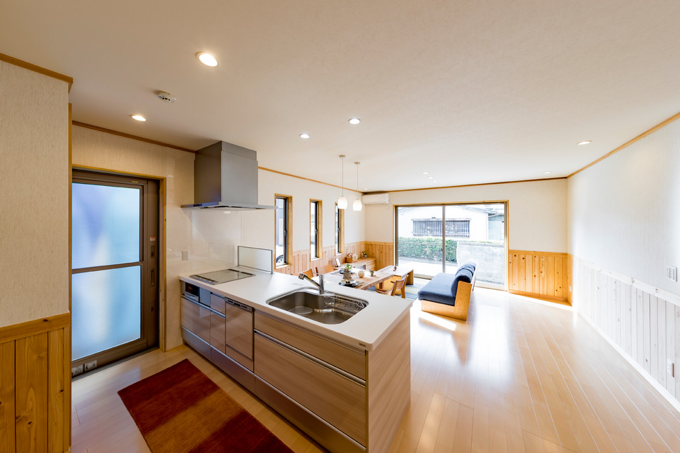 Exemple d'une cuisine ouverte linéaire asiatique avec un évier 1 bac, un placard à porte plane, des portes de placard beiges, parquet peint, une péninsule et un sol beige.