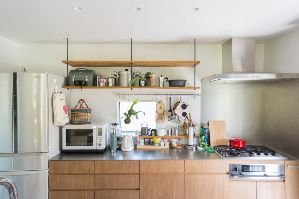 Mittelgroße, Einzeilige Shabby-Style Wohnküche mit Unterbauwaschbecken, Edelstahl-Arbeitsplatte, Betonboden, Kücheninsel, grauem Boden und brauner Arbeitsplatte in Sonstige