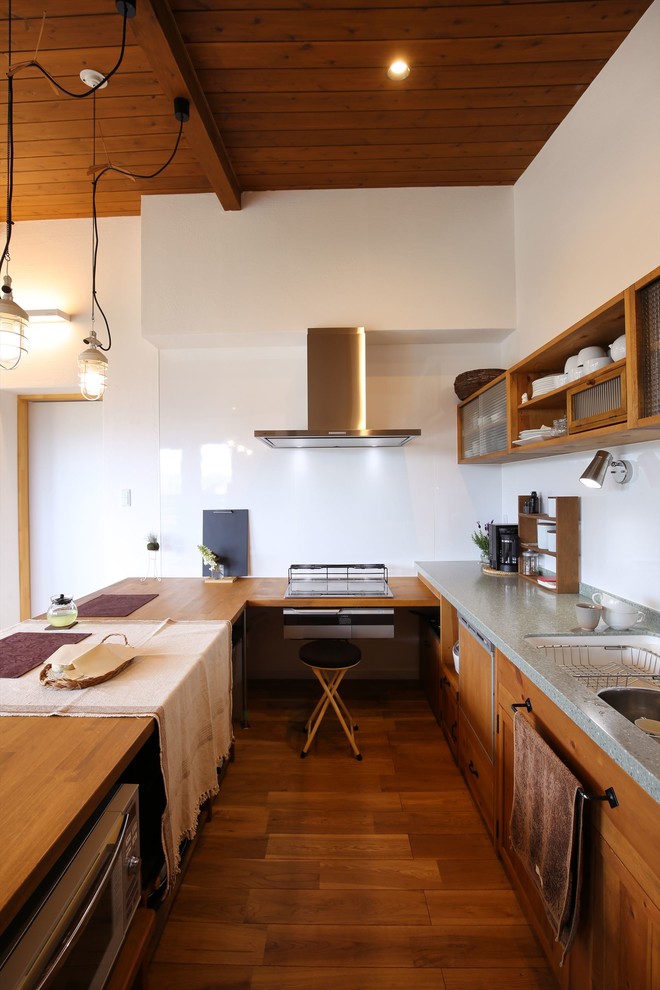 Idéer för att renovera ett orientaliskt kök, med en enkel diskho, släta luckor, skåp i mellenmörkt trä, träbänkskiva, vitt stänkskydd, mellanmörkt trägolv och brunt golv