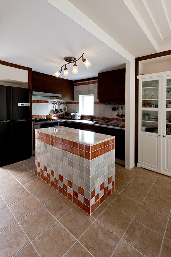 На фото: угловая кухня в классическом стиле с плоскими фасадами, коричневыми фасадами, серым фартуком, техникой из нержавеющей стали и островом с
