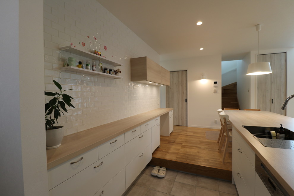 Пример оригинального дизайна: параллельная кухня-гостиная в скандинавском стиле с полом из терракотовой плитки, островом и серым полом