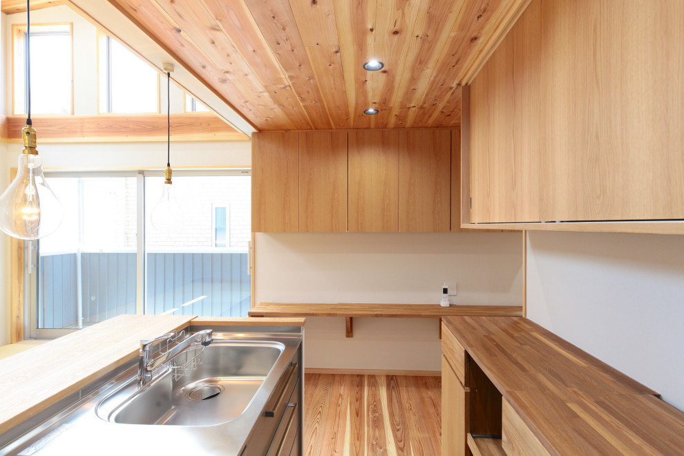 Foto di una cucina chic di medie dimensioni con ante in acciaio inossidabile, top in acciaio inossidabile, paraspruzzi bianco, pavimento in legno massello medio, pavimento beige e top beige