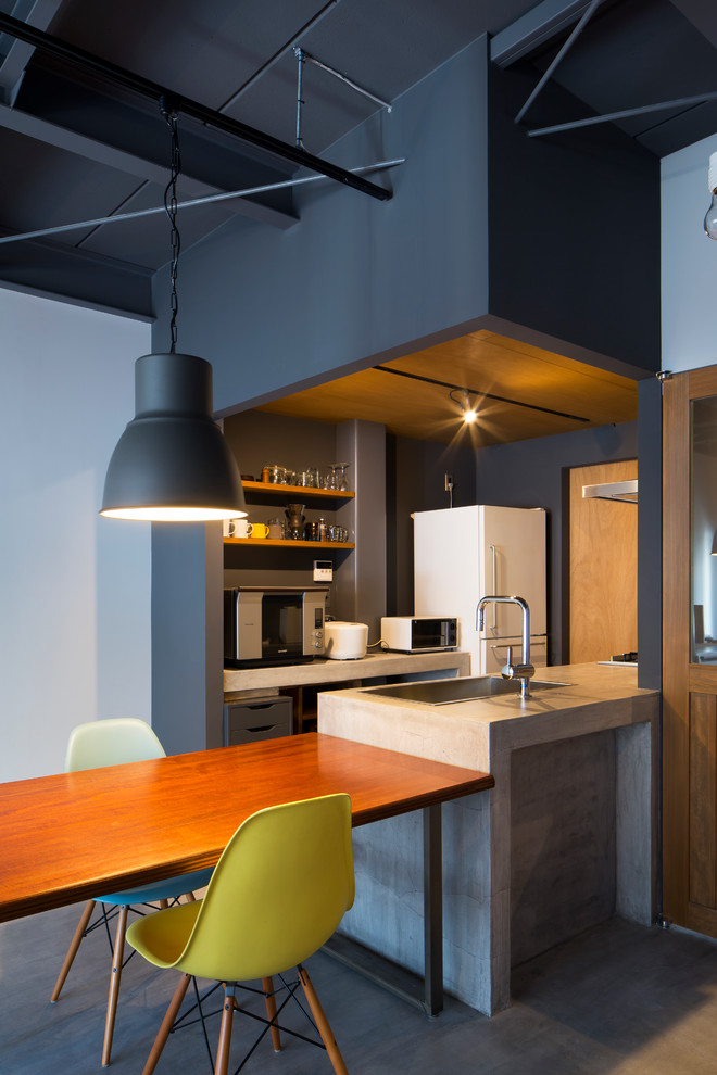 Idéer för små industriella grått kök, med grå skåp, bänkskiva i betong, rostfria vitvaror, en halv köksö, en undermonterad diskho, stänkskydd med metallisk yta, betonggolv och grått golv