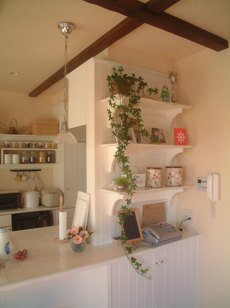 На фото: маленькая кухня-гостиная в стиле шебби-шик с одинарной мойкой, столешницей из плитки, белым фартуком, полом из фанеры и полуостровом для на участке и в саду с