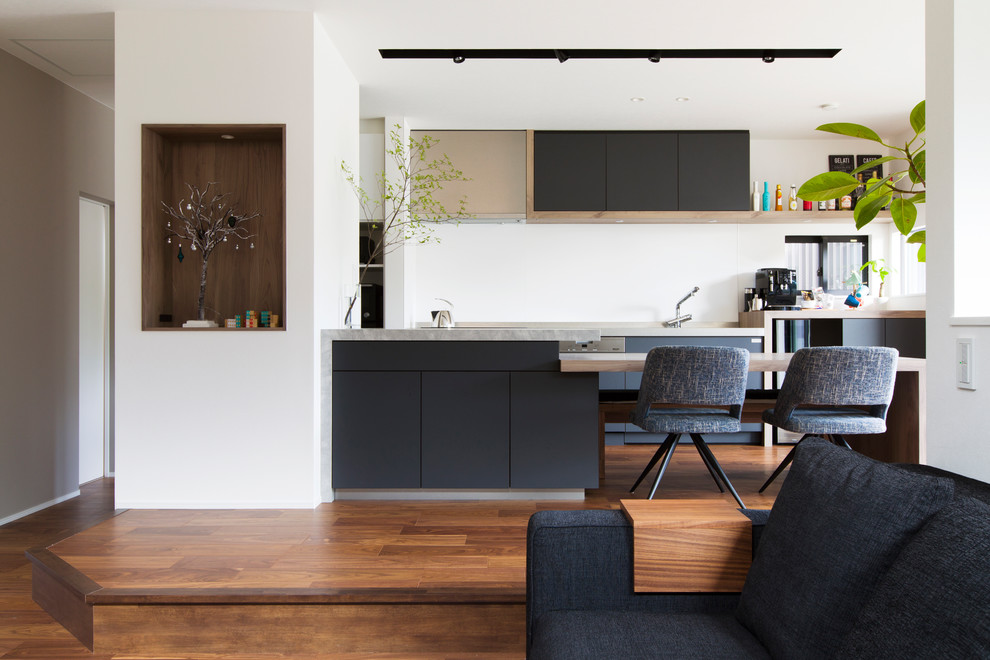 Example of a galley dark wood floor and brown floor open concept kitchen design in Nagoya with flat-panel cabinets, black cabinets, wood countertops and white backsplash
