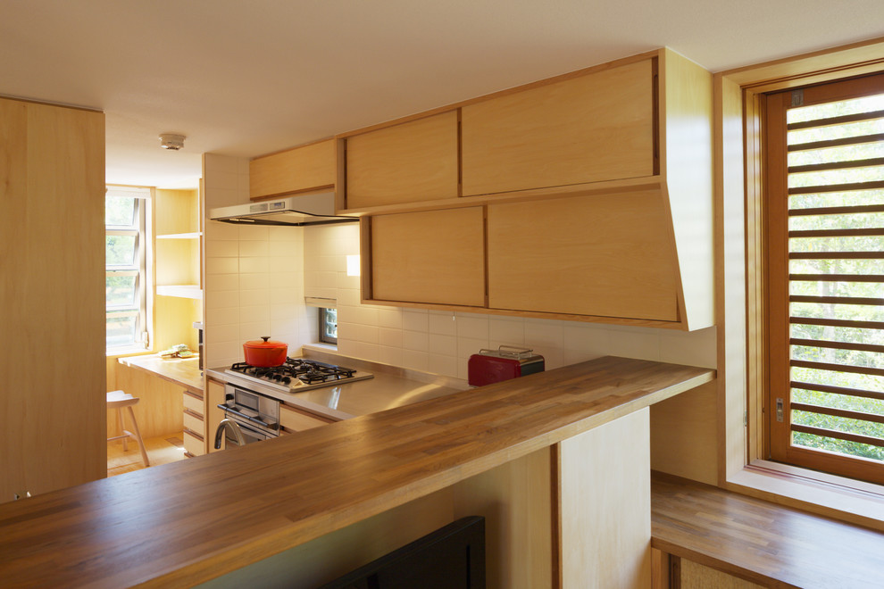 Foto de cocina comedor lineal de estilo zen con puertas de armario de madera clara, encimera de acero inoxidable y electrodomésticos de acero inoxidable