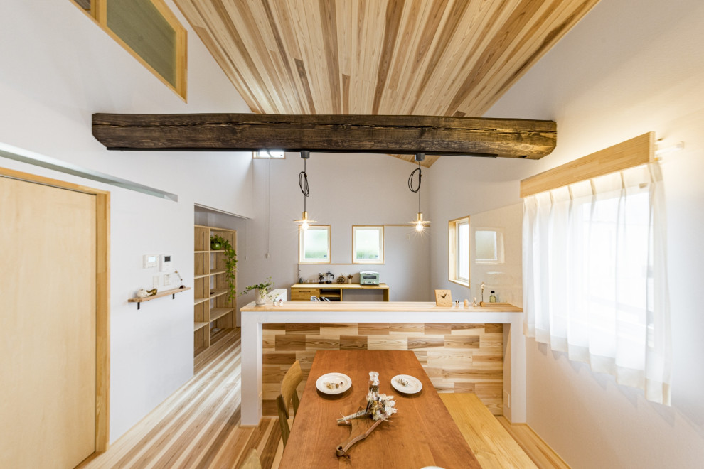Idéer för att renovera ett mellanstort funkis grå linjärt grått kök med öppen planlösning, med en integrerad diskho, luckor med profilerade fronter, svarta skåp, bänkskiva i rostfritt stål, vitt stänkskydd, glaspanel som stänkskydd, rostfria vitvaror, mellanmörkt trägolv, en köksö och beiget golv