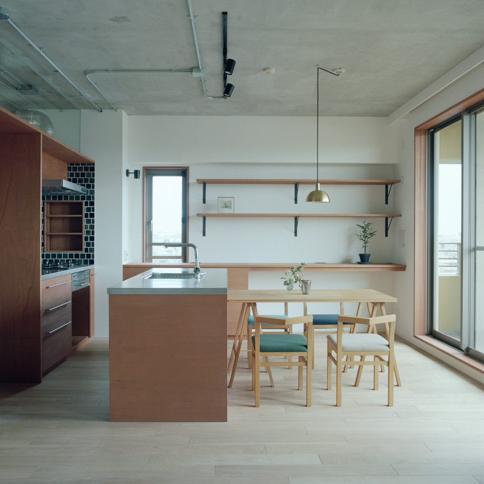 Photo of a small scandinavian galley open plan kitchen in Tokyo Suburbs with an integrated sink, flat-panel cabinets, medium wood cabinets, stainless steel worktops, black splashback, glass tiled splashback, stainless steel appliances, light hardwood flooring and an island.