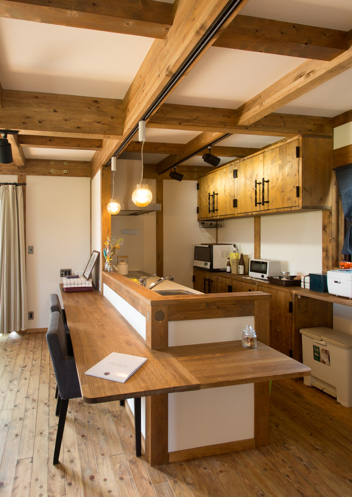 名古屋にあるアジアンスタイルのおしゃれなキッチン (ドロップインシンク、フラットパネル扉のキャビネット、中間色木目調キャビネット、木材カウンター、無垢フローリング、茶色い床、青いキッチンカウンター) の写真