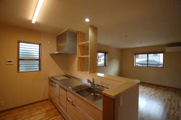 Exempel på ett mellanstort klassiskt kök med öppen planlösning, med en integrerad diskho, luckor med profilerade fronter, vita skåp, bänkskiva i rostfritt stål, vitt stänkskydd, mellanmörkt trägolv och brunt golv