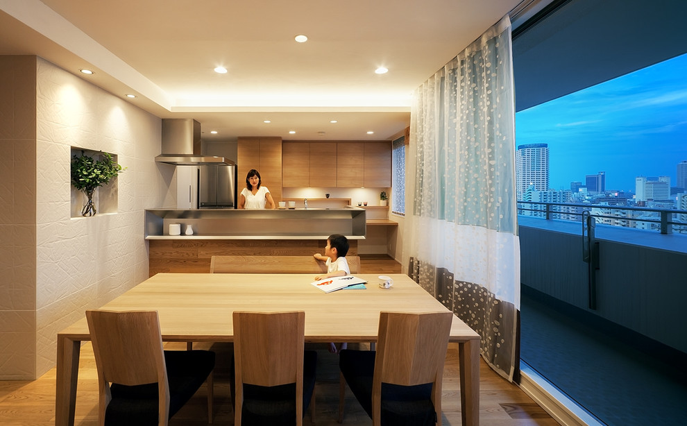 神戸にあるコンテンポラリースタイルのおしゃれなキッチン (フラットパネル扉のキャビネット、中間色木目調キャビネット、ステンレスカウンター、白いキッチンパネル、シルバーの調理設備、無垢フローリング、茶色い床、グレーのキッチンカウンター) の写真