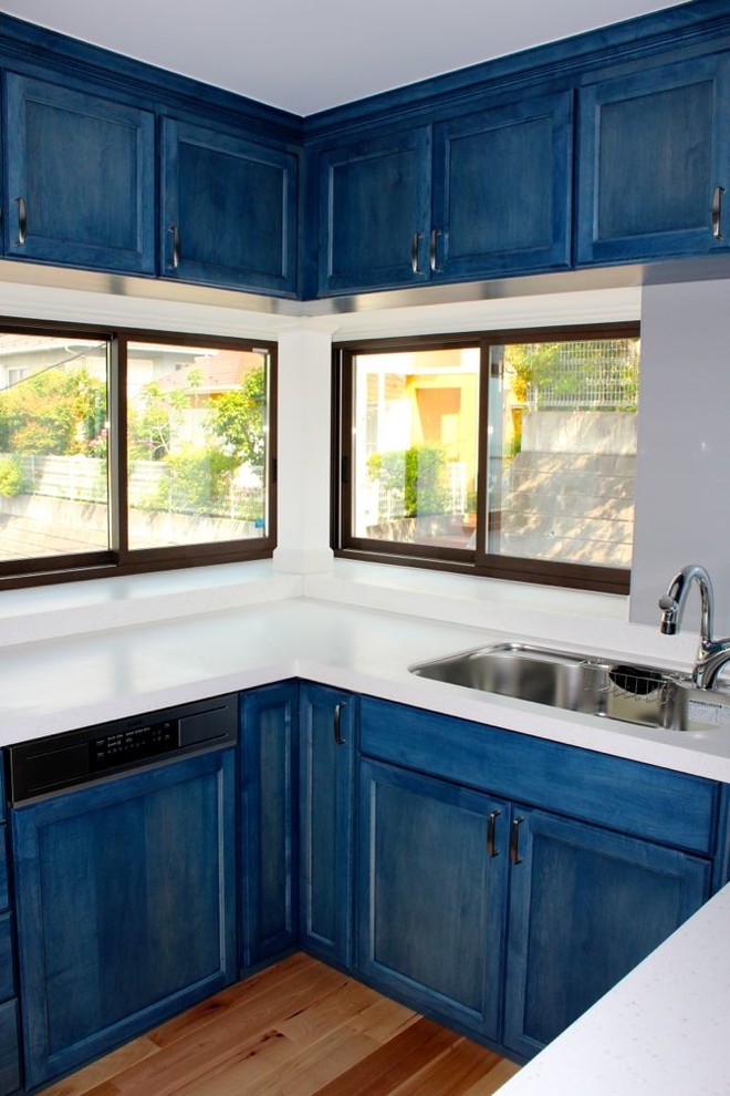 Idéer för mellanstora funkis kök, med luckor med upphöjd panel, blå skåp, bänkskiva i täljsten, en undermonterad diskho, grått stänkskydd, rostfria vitvaror och mellanmörkt trägolv