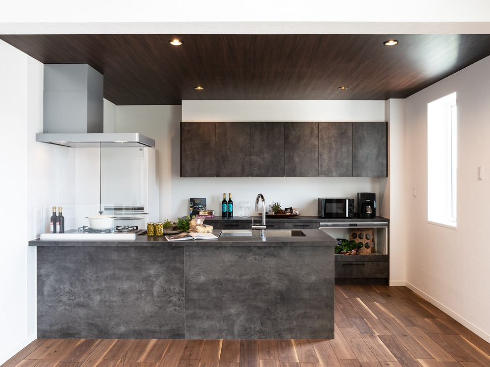 Bild på ett funkis grå linjärt grått kök med öppen planlösning, med flera köksöar